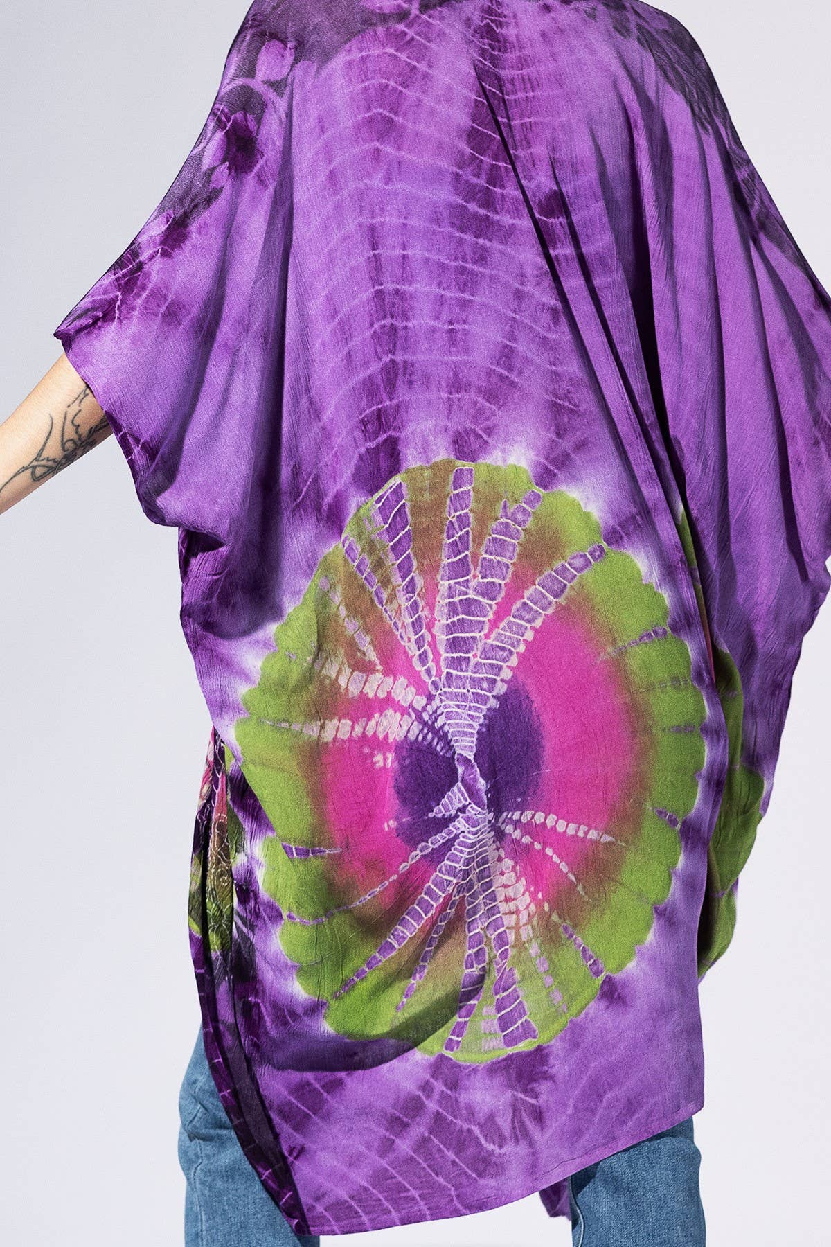 Purple tie-dye shirt with a circular pattern on a plain background