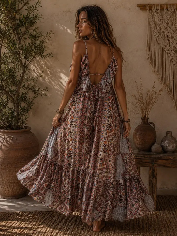 Woman in a patterned dress standing in a rustic indoor setting with plants and decor.
