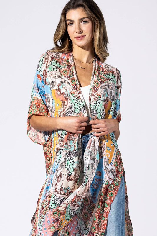 Woman wearing a colorful patterned kimono-style garment on a white background