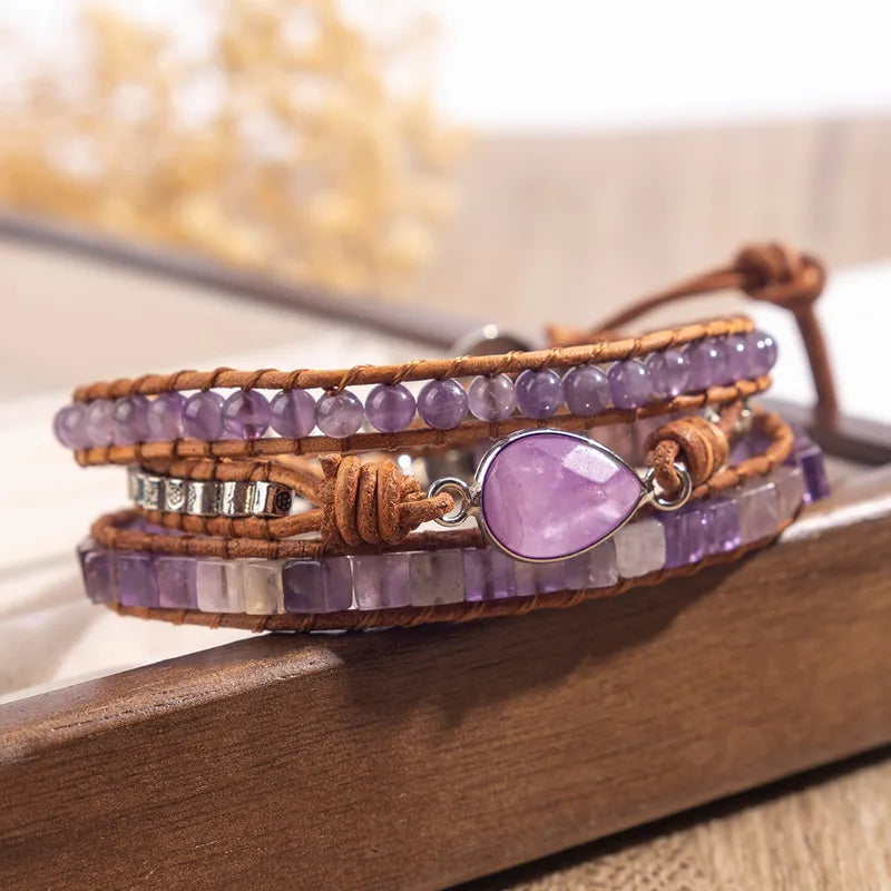 Purple beaded bracelet with a heart-shaped charm on a wooden surface