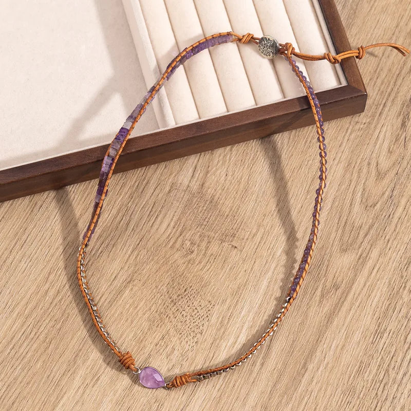 Necklace with a purple heart-shaped pendant on a wooden surface