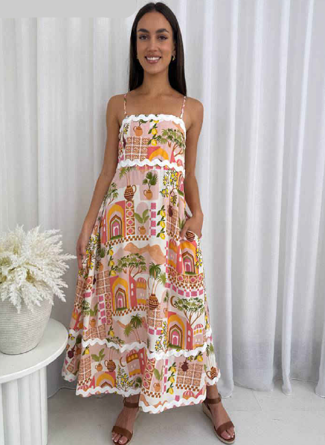 Woman wearing a patterned dress standing against a white curtain
