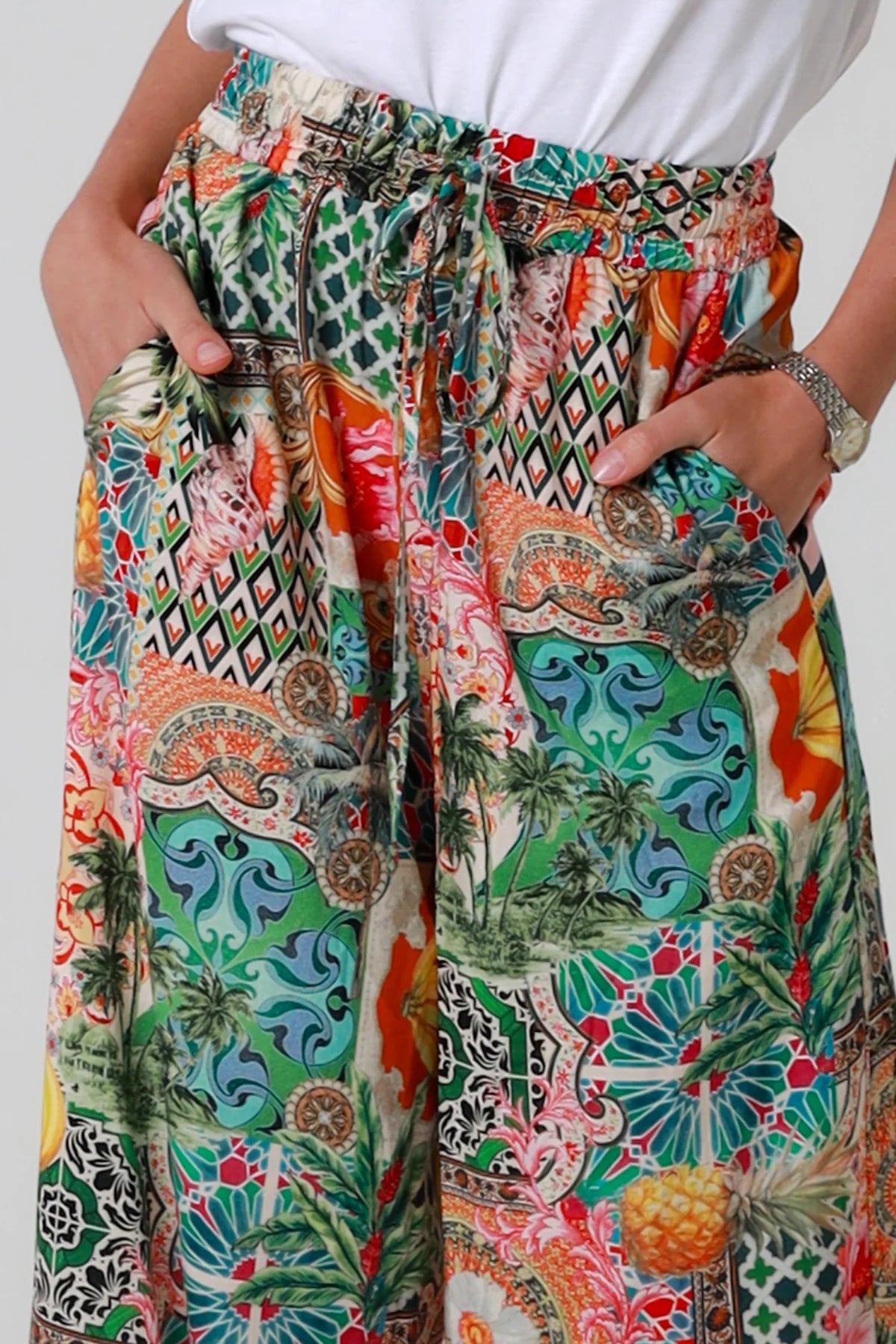 Colorful patterned pants with a white top on a plain background