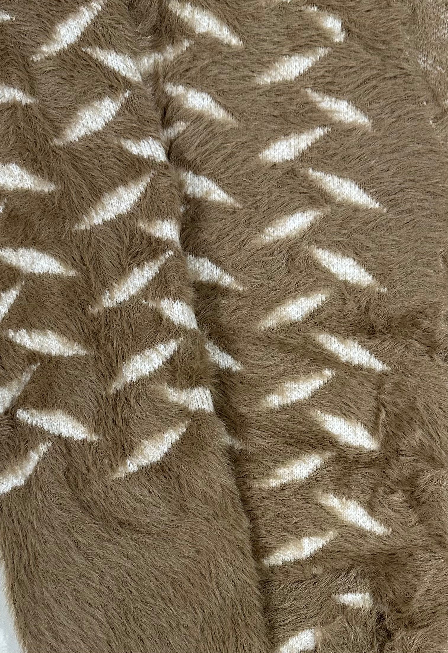 Close-up of a textured brown fabric with white patterns