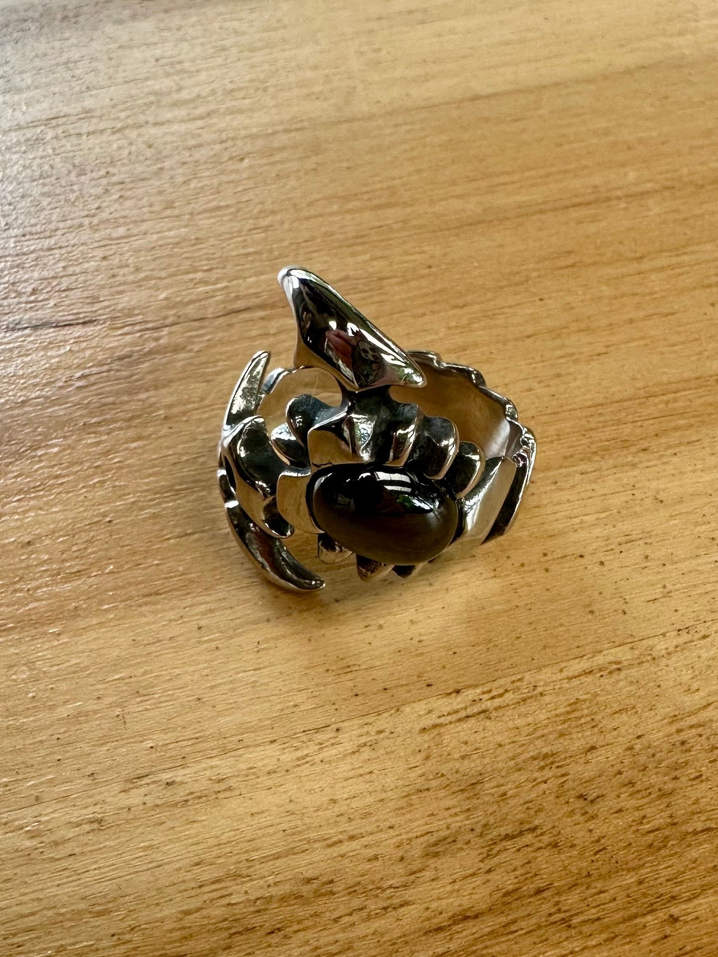 Silver crab-shaped object on a wooden surface