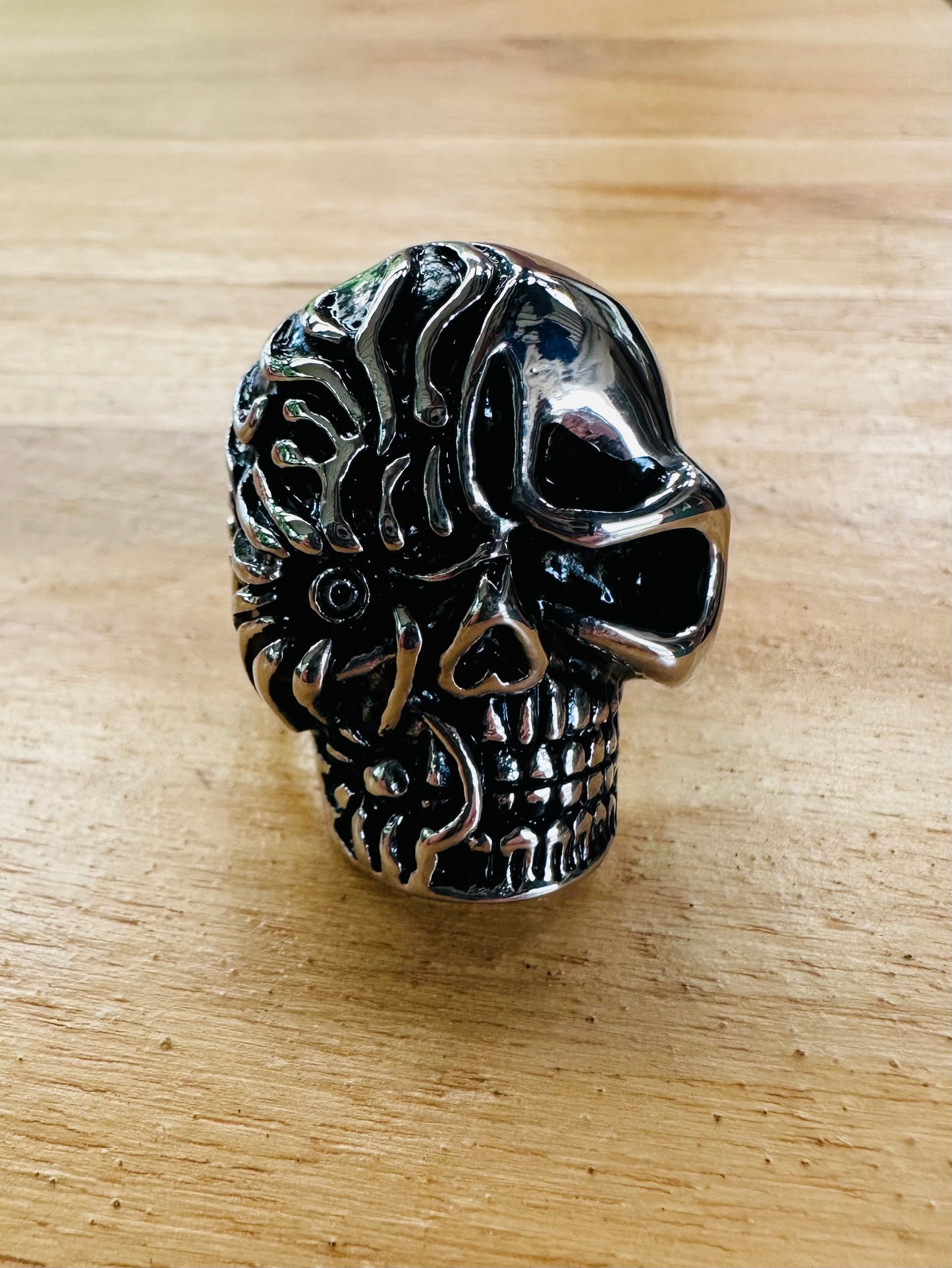 Silver skull ring on a wooden surface