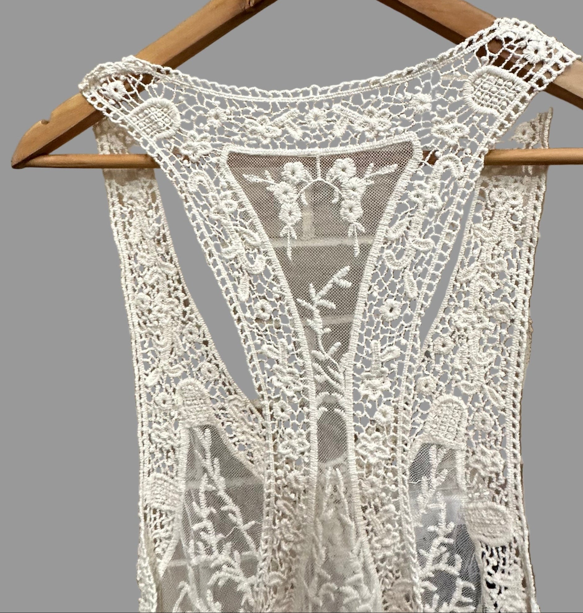 Lace dress on a hanger against a tiled wall