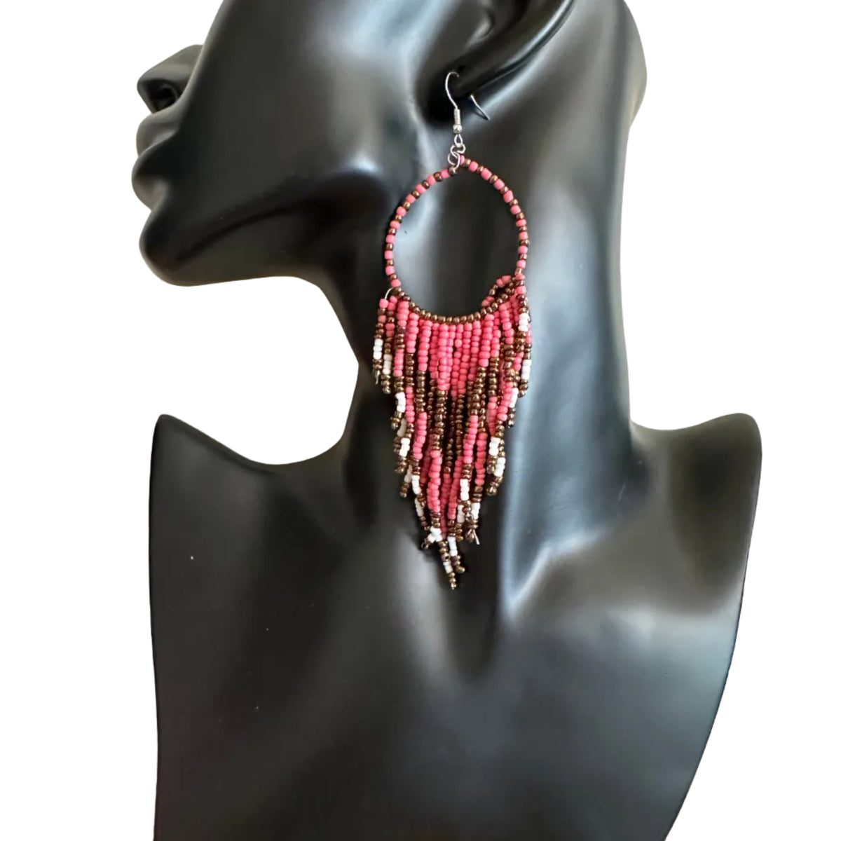 A pair of large hoop earrings with dangling beaded fringe in pink, red, and metallic silver, displayed on a black mannequin bust.
