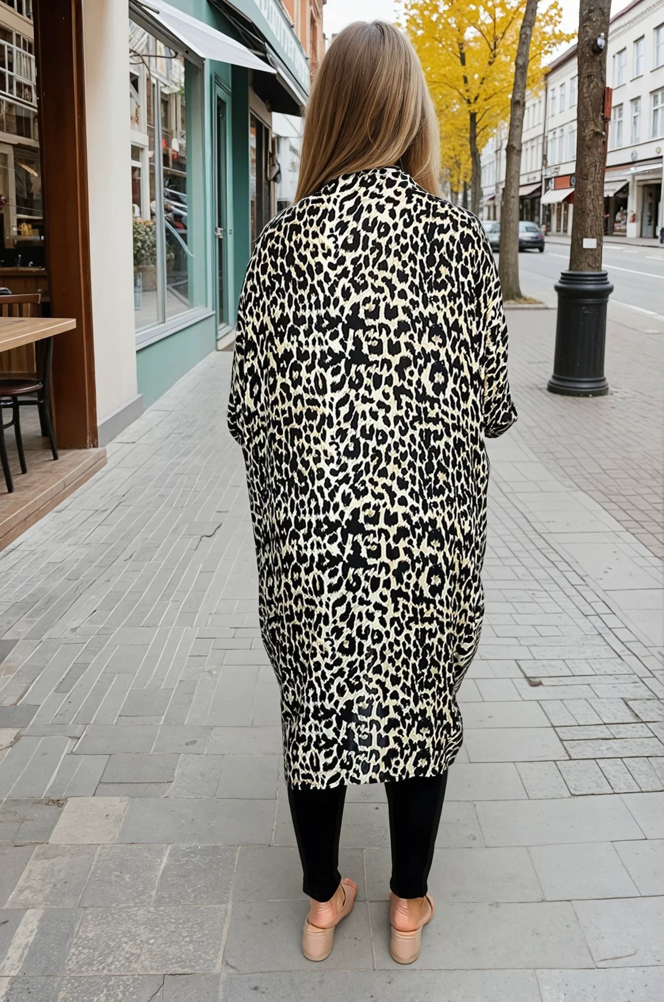 Person wearing a leopard print coat on a city street