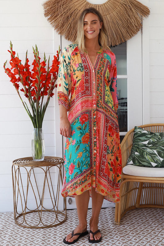 Woman wearing a colorful dress standing in a room with decorative elements.