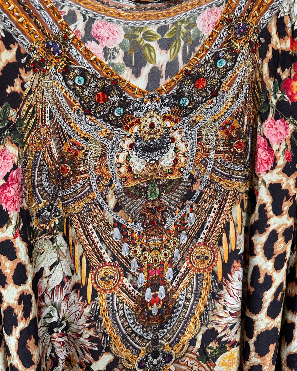 Decorative fabric with intricate patterns, including floral and leopard print elements, featuring beads and sequins.
