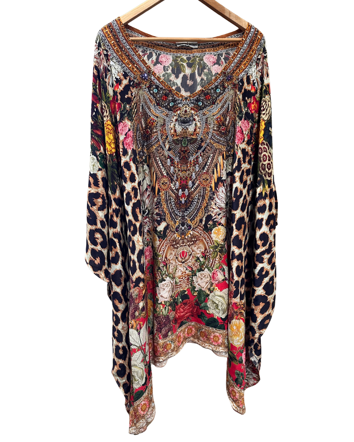 Multicolored patterned top with leopard print on a hanger against a white background