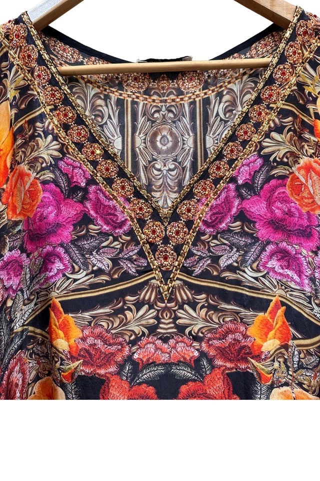 Colorful floral and patterned top on a hanger