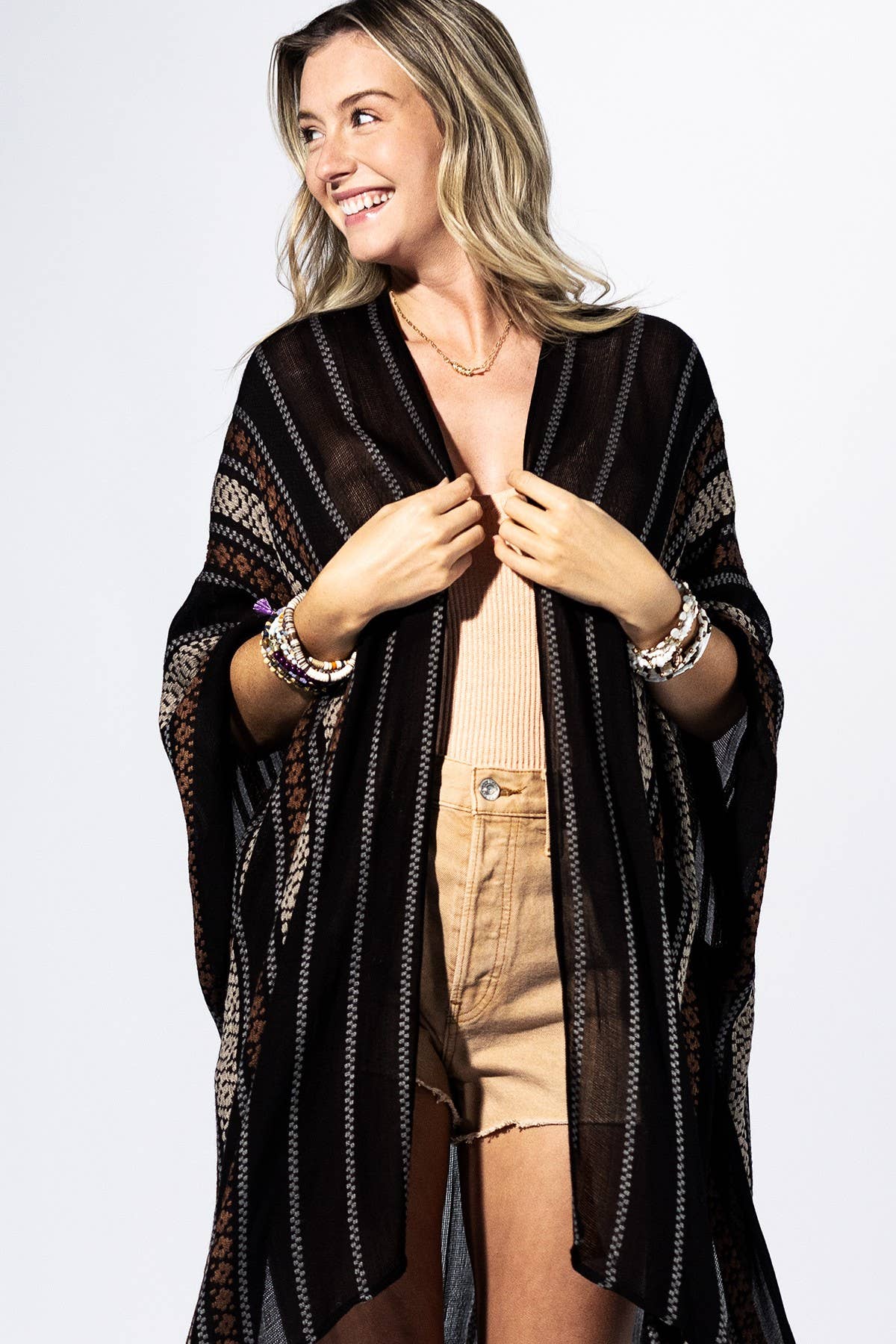 Woman wearing a black patterned kimono-style garment on a white background