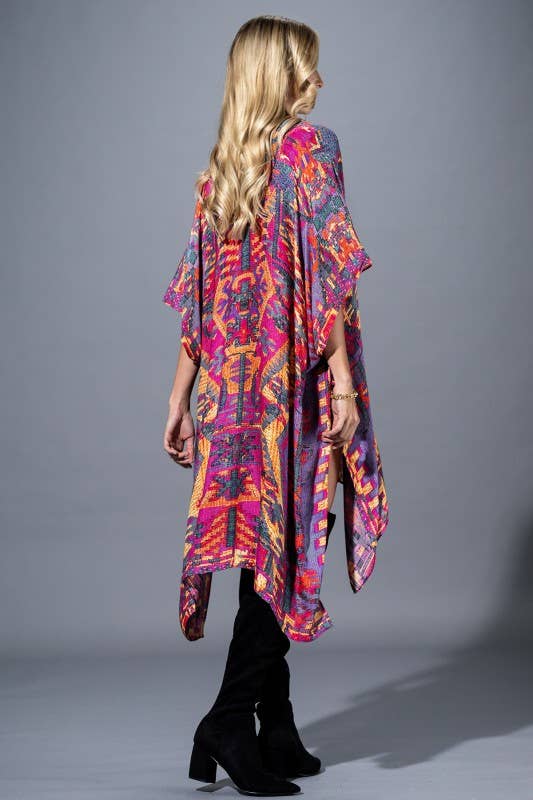 Woman wearing a colorful patterned kimono-style garment against a gray background