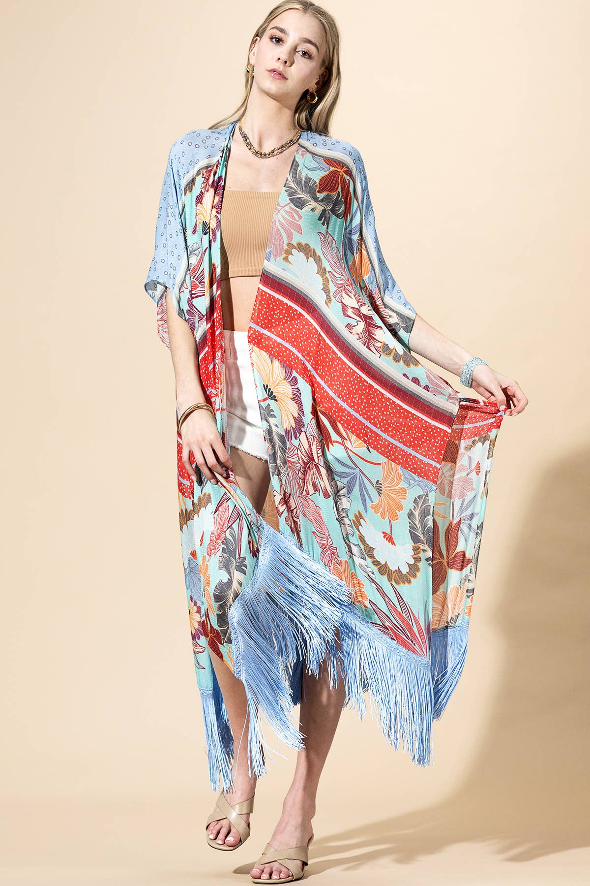 Woman wearing a colorful kimono-style garment on a beige background