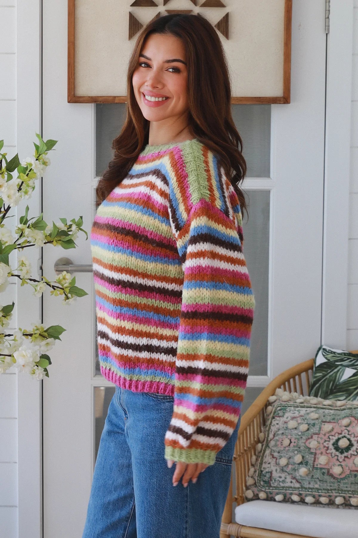 Woman wearing a colorful striped sweater in a home setting