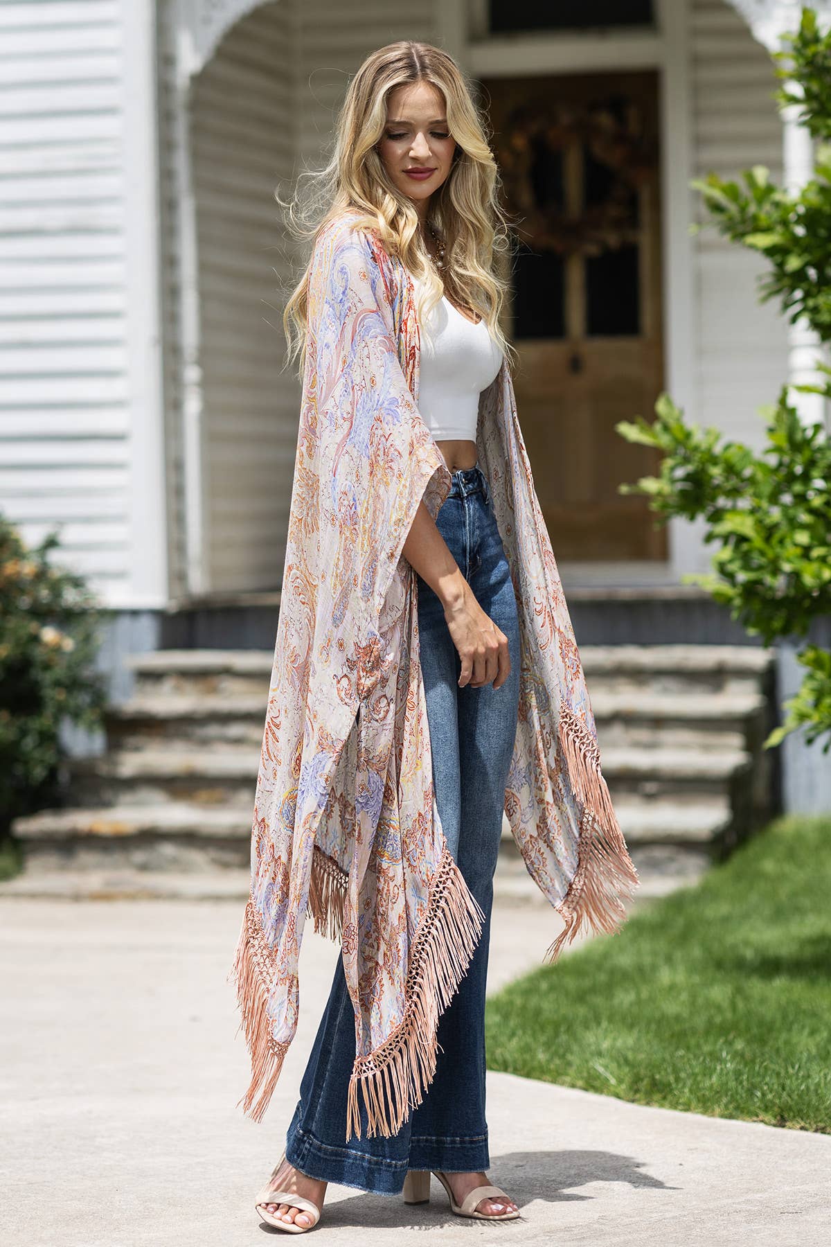 Woman wearing a floral kimono in front of a house