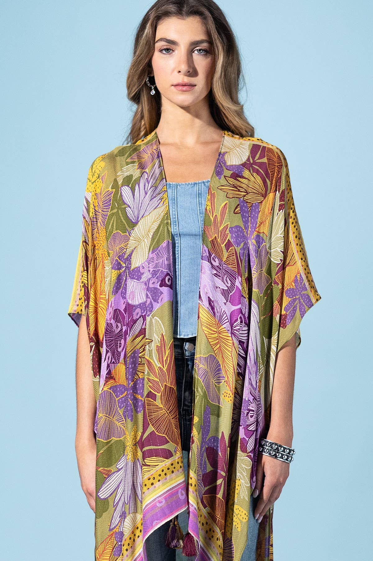 Woman wearing a colorful floral kimono against a light blue background