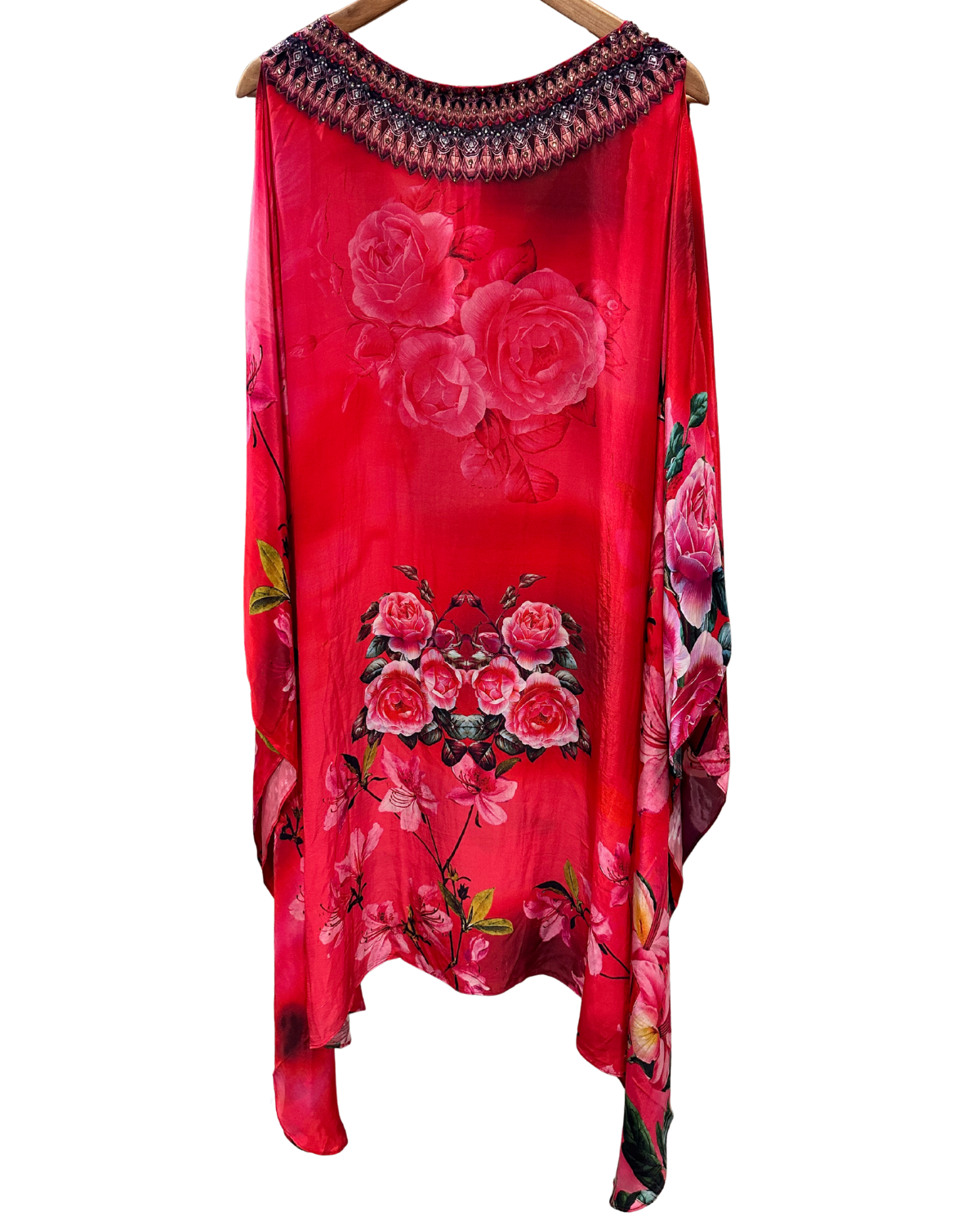 Red dress with floral patterns on a hanger against a white background