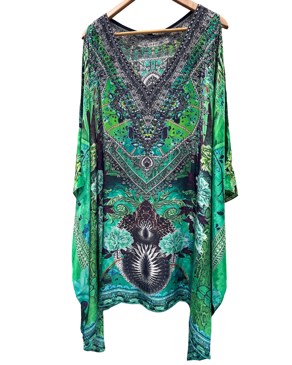 Green patterned dress on a hanger against a white background