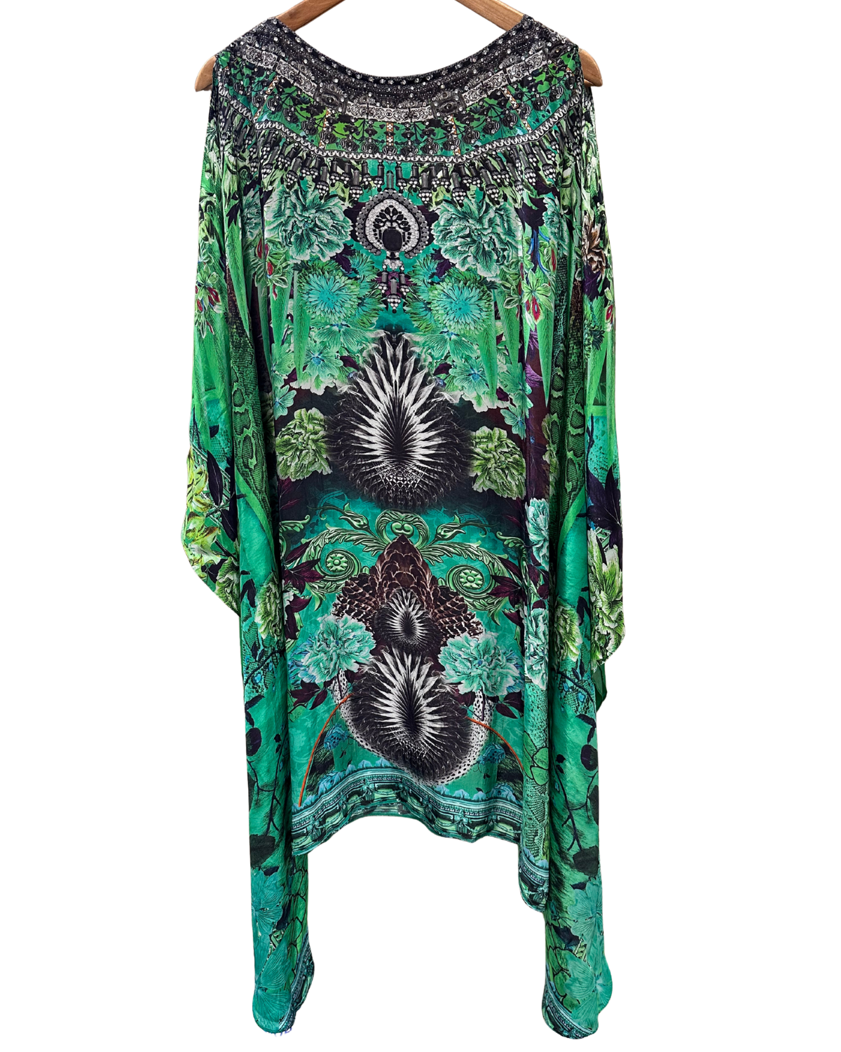 Green patterned dress on a hanger against a white background