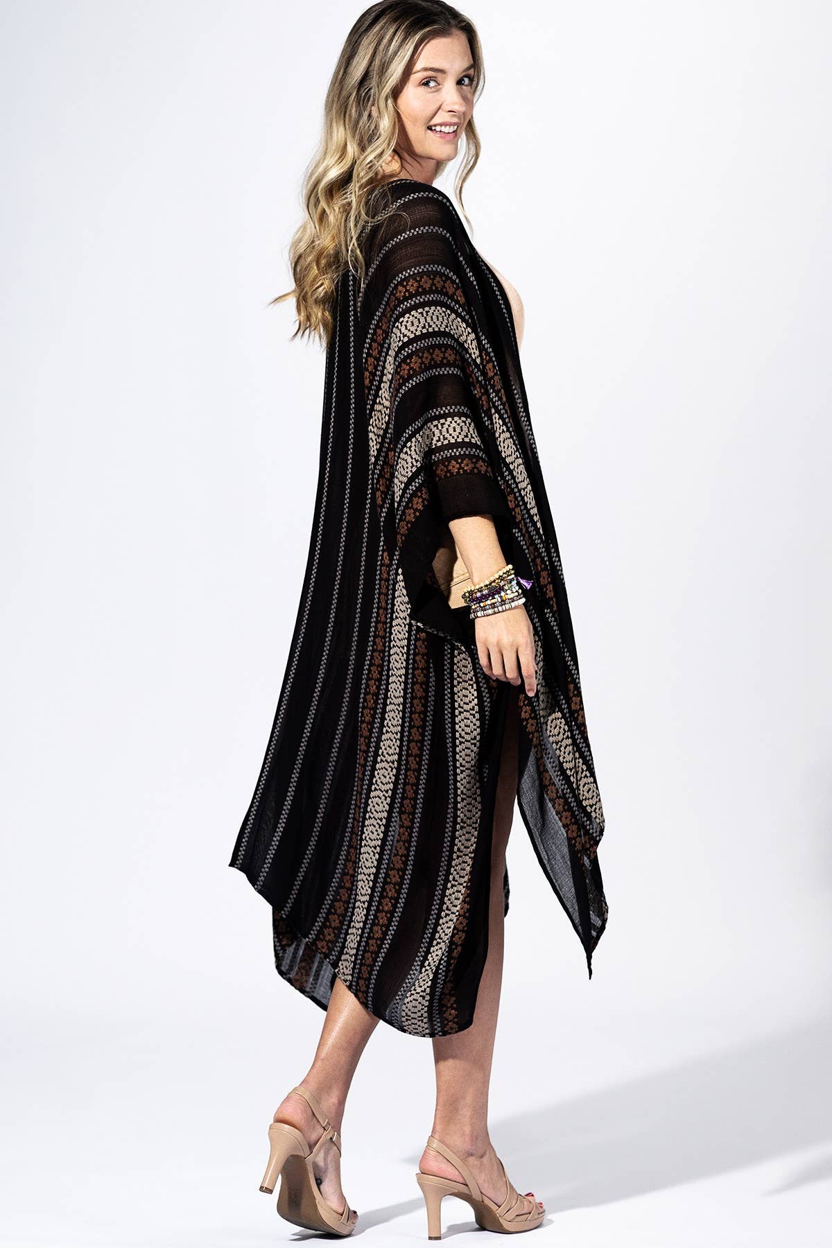 Woman wearing a black and brown striped poncho on a white background
