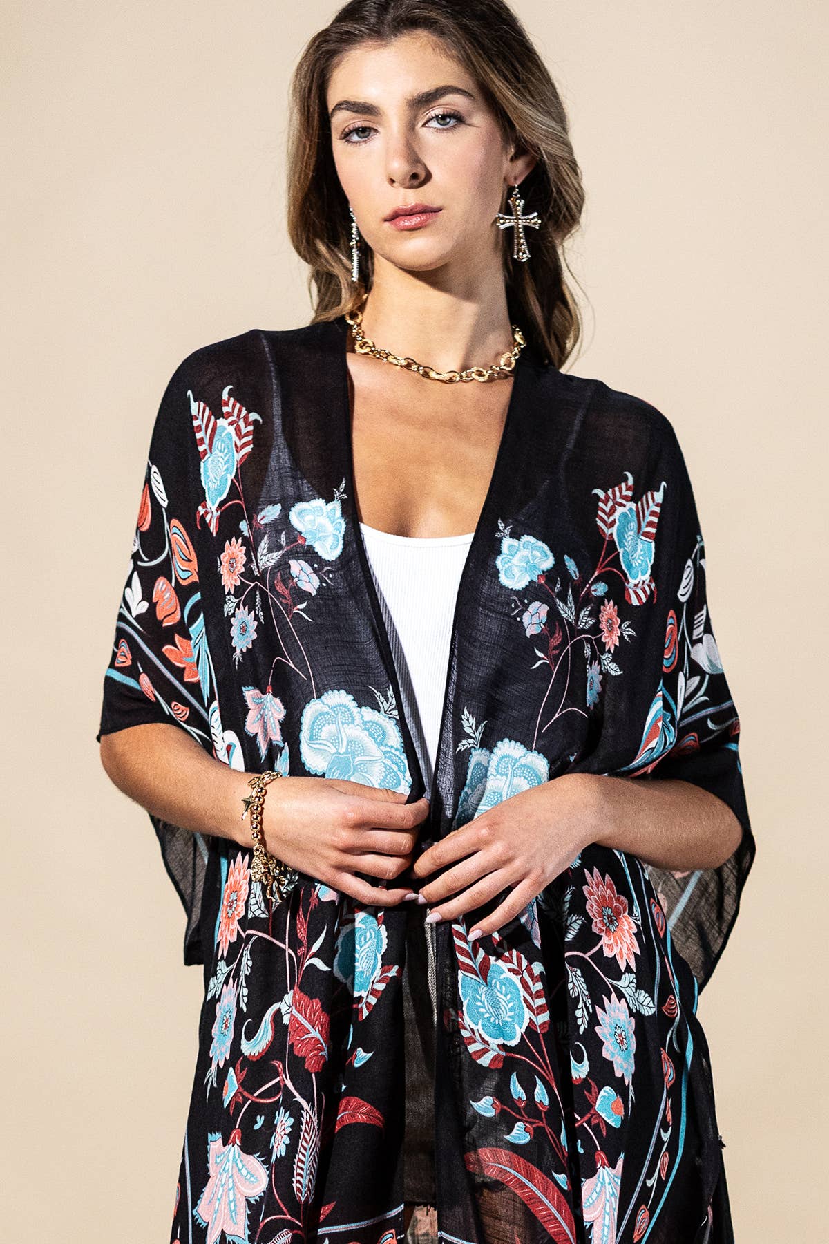 Woman wearing a black floral kimono against a beige background