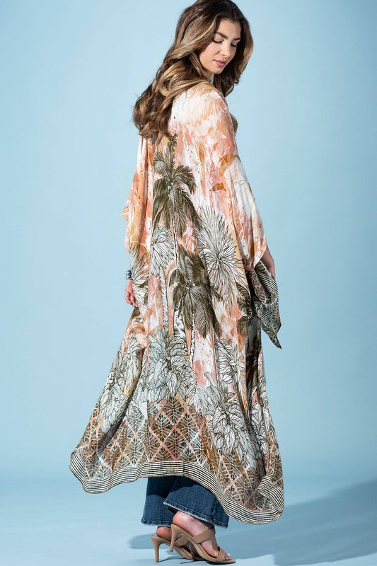 Woman wearing a long, patterned dress against a light blue background