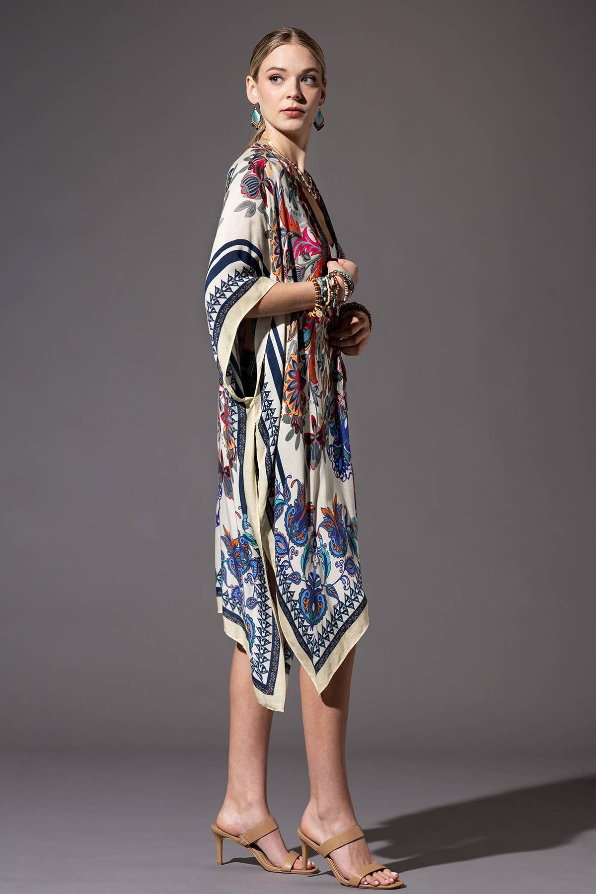 Woman wearing a patterned kimono-style garment against a gray background