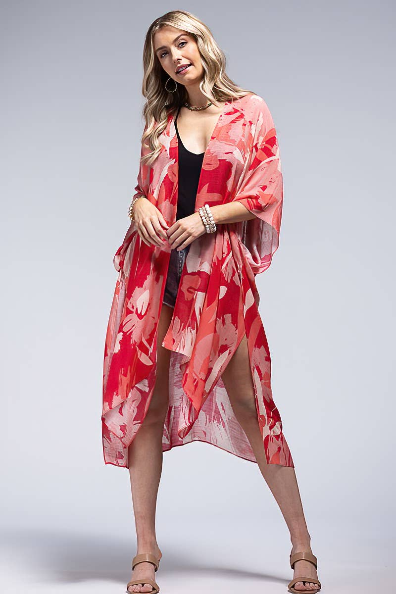 Woman wearing a red floral kimono over a black top on a gray background