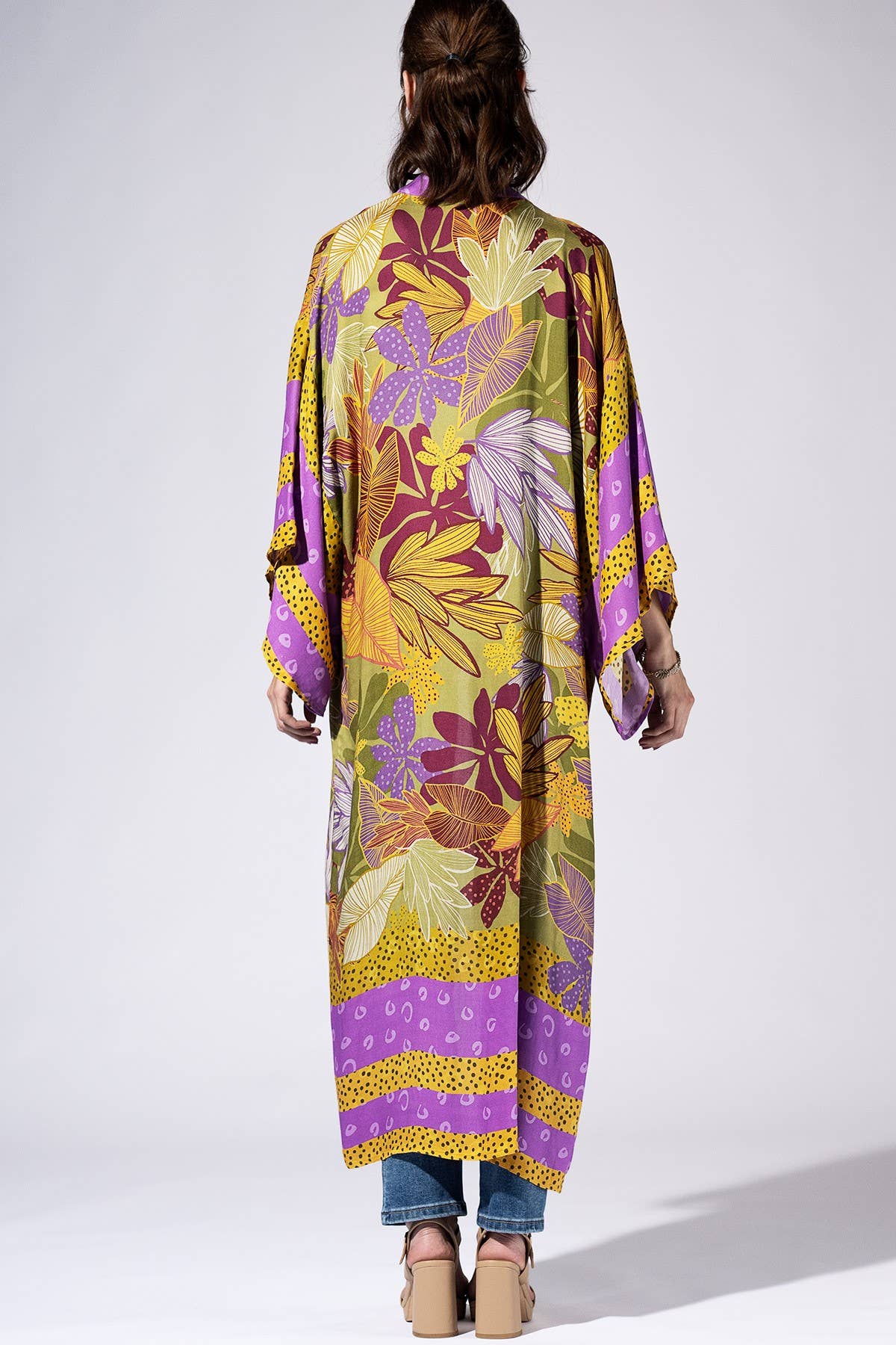 Person wearing a colorful floral kimono-style garment on a white background