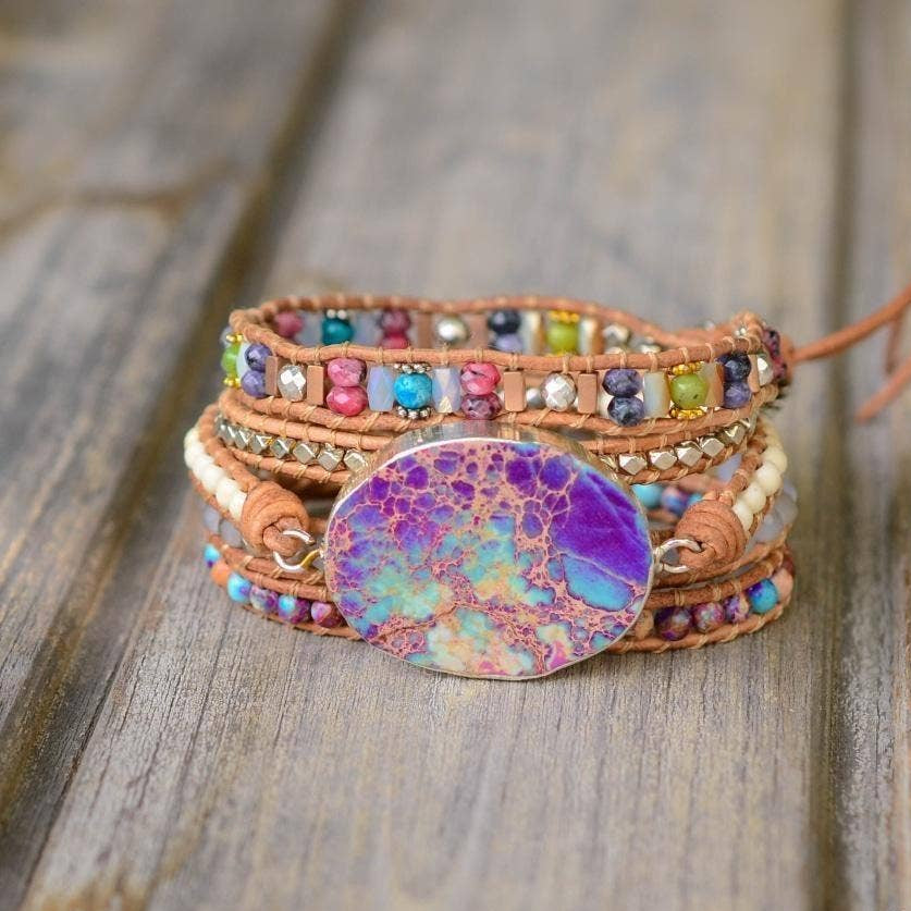 Multicolored beaded bracelet with a large round stone on a wooden surface.